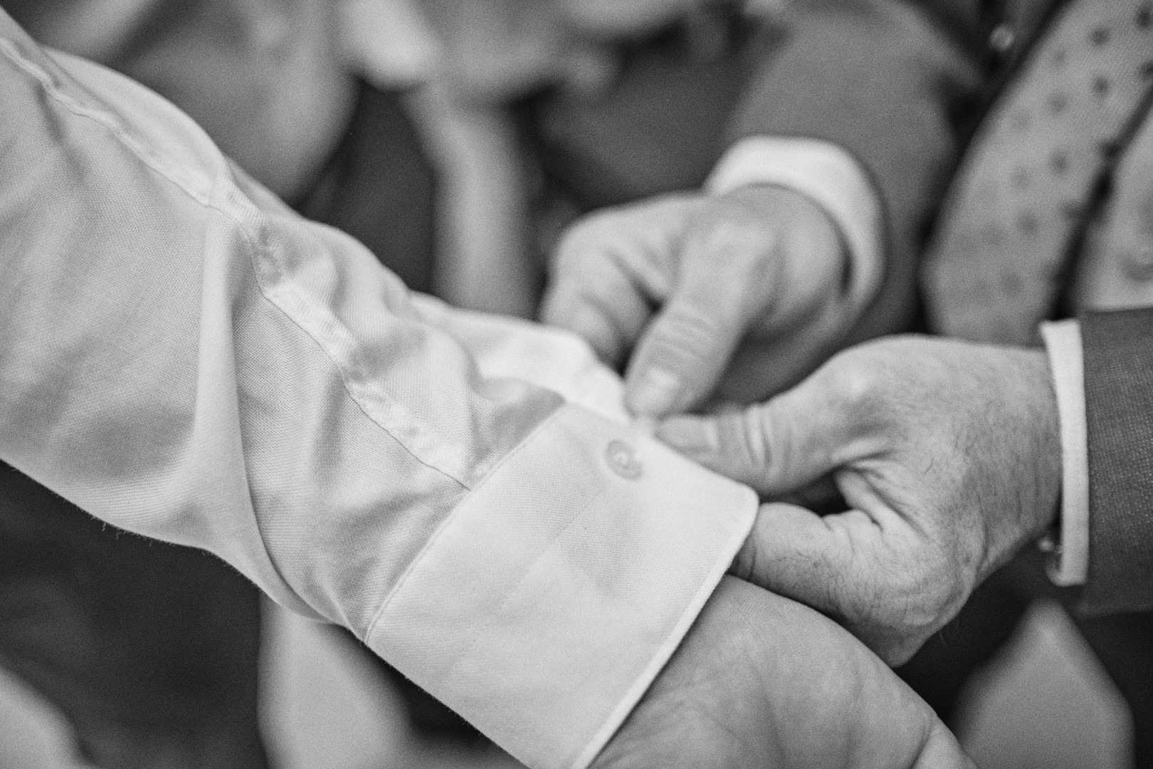 A friend helps Alejandro adjust his outfit.