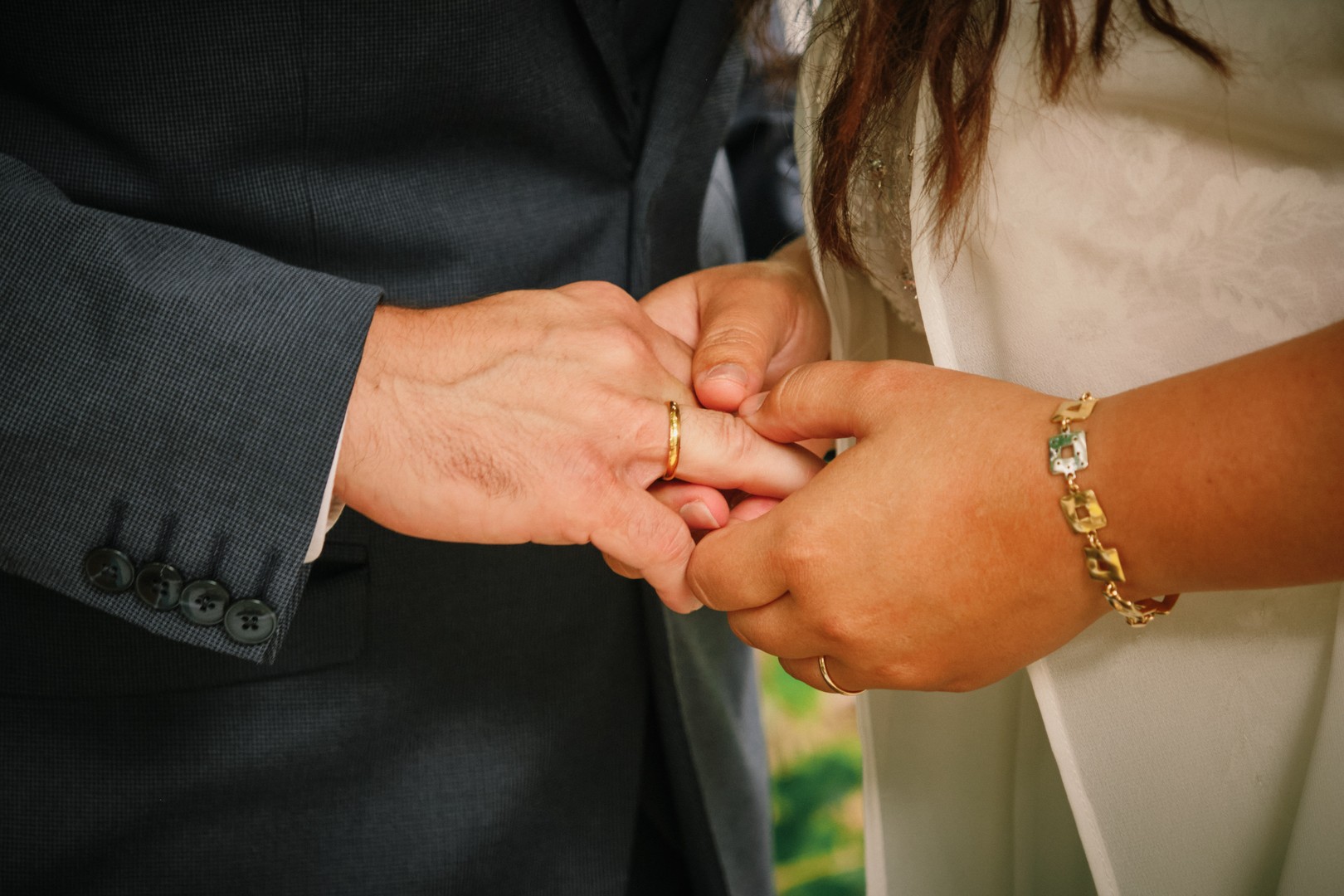 Close-up of the couple’s hands as they exchange rings.