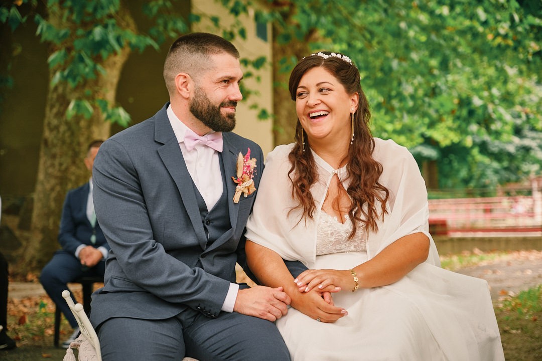 Miriam and Alejandro burst out laughing, sitting side by side.