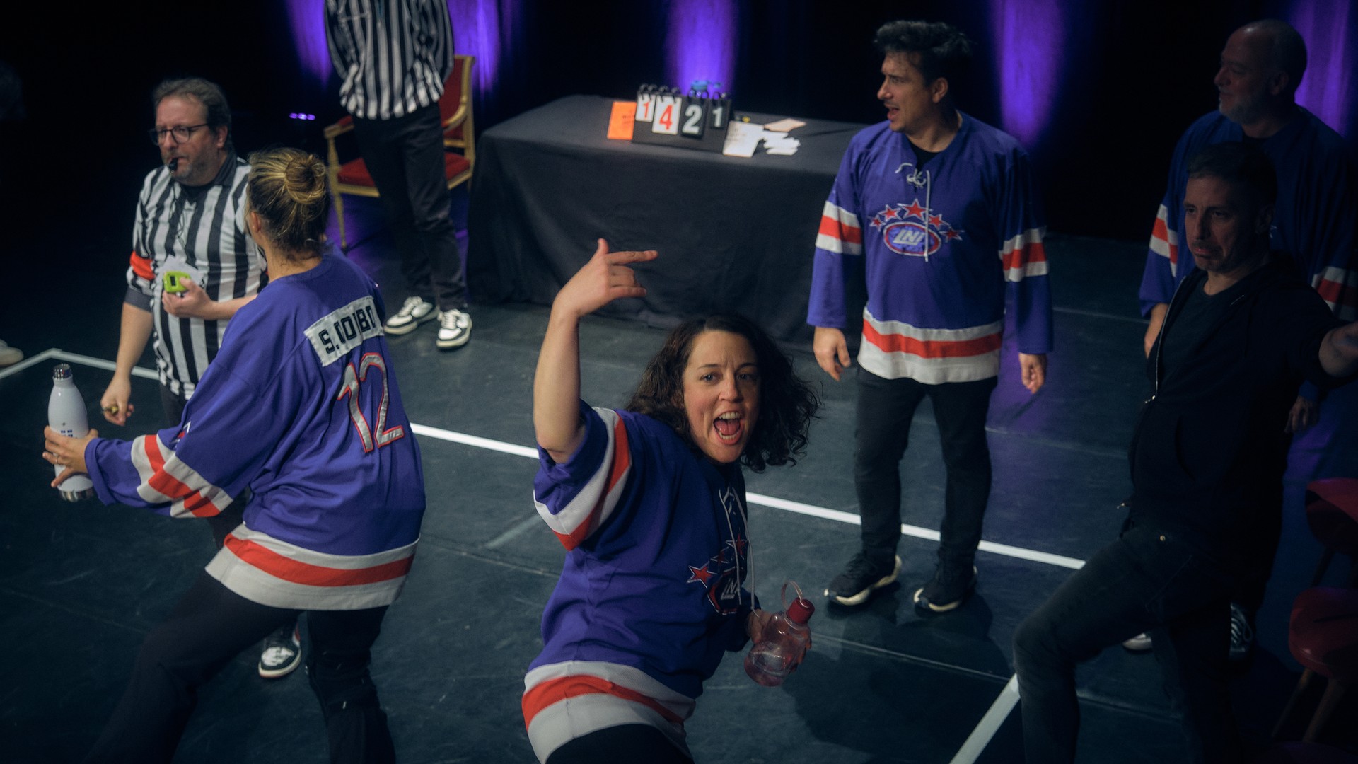 Several performers improvise on stage at the theatre.