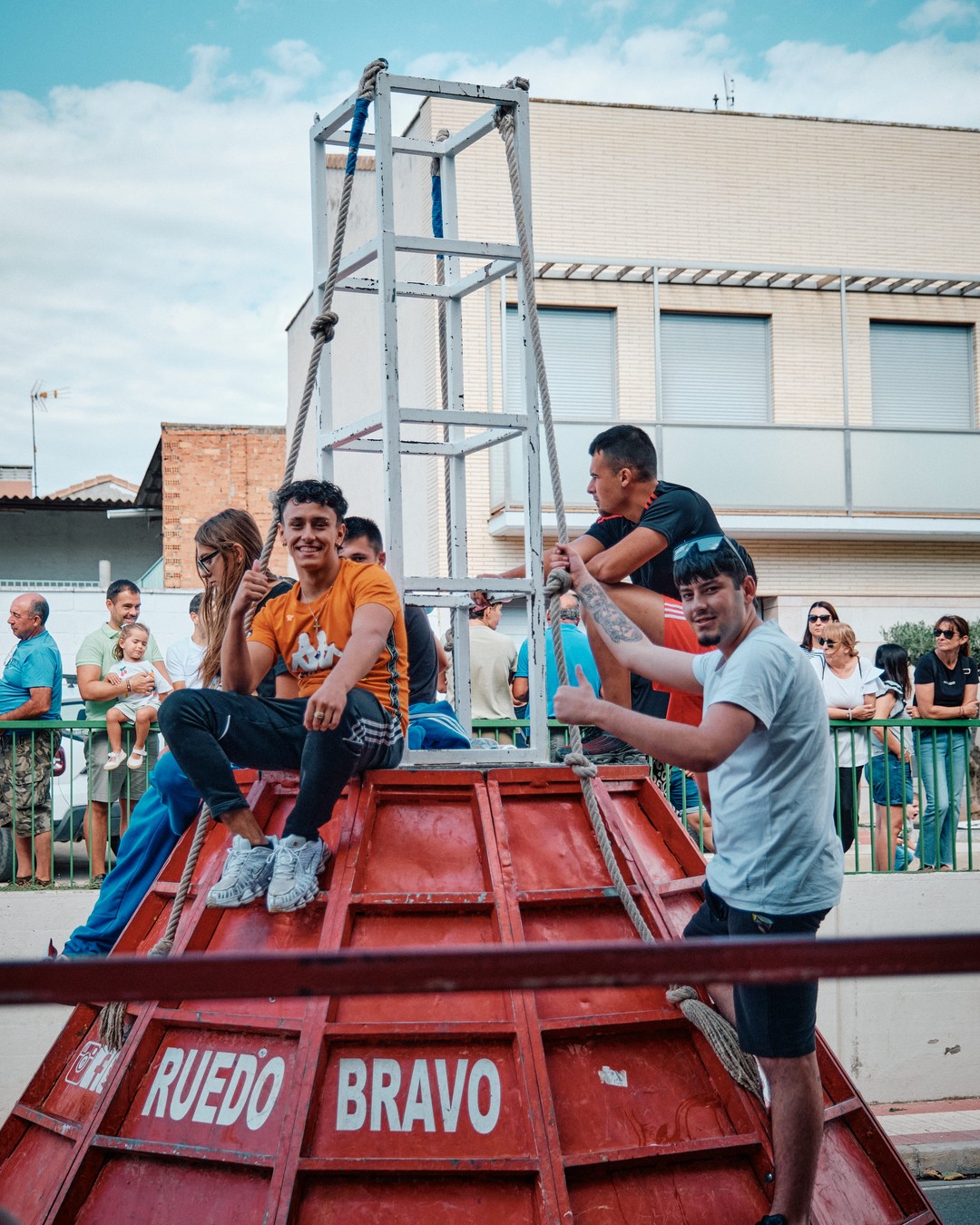 Varios participantes se suben a una estructura de protección junto al recorrido.