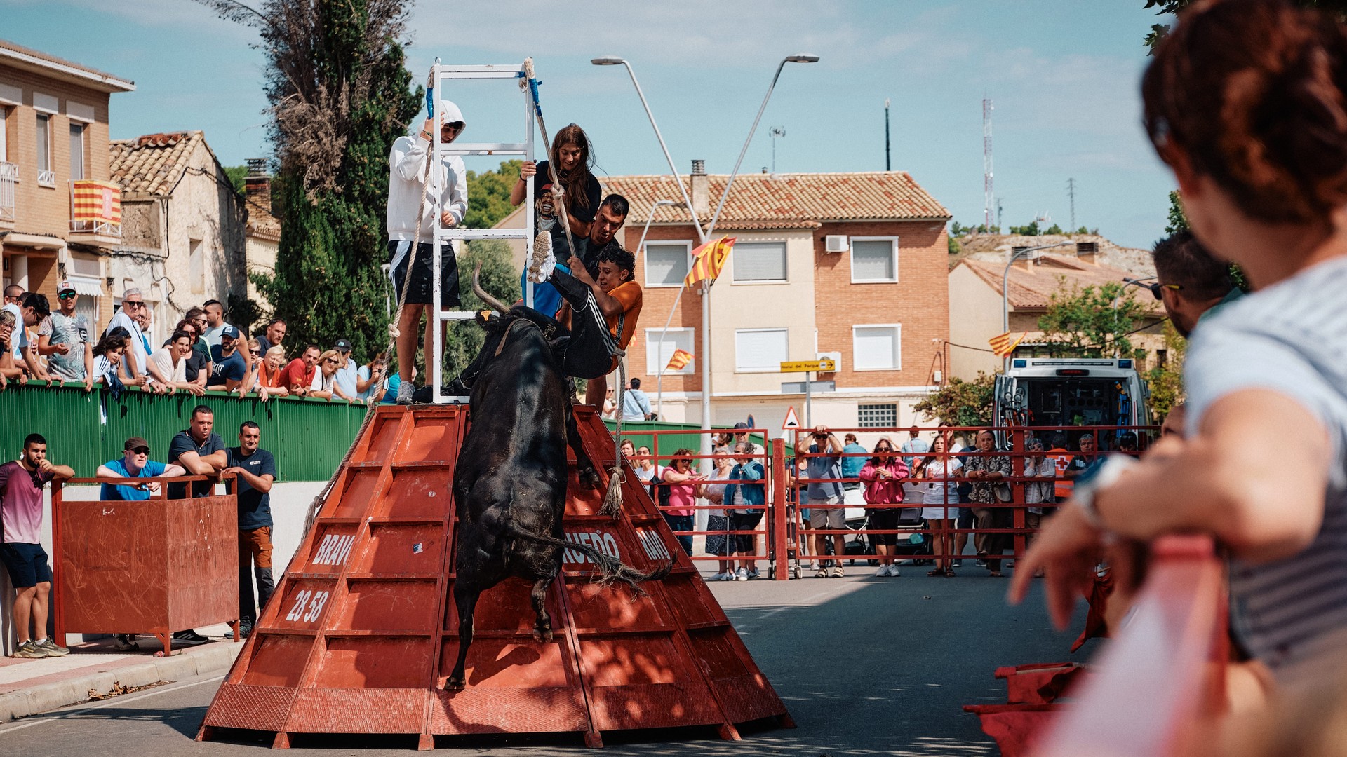 Un toro se encabrita junto a una estructura roja del recorrido.