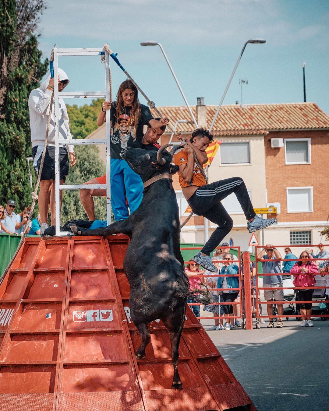 Varios participantes se refugian en una estructura roja cuando pasa el toro.